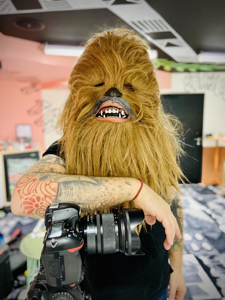 Une personne avec un masque de Chewbacca prend sa pause en se posant sur une caméra.